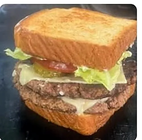 Double cheeseburger stacked on thick Texas toast with lettuce, tomato and pickles